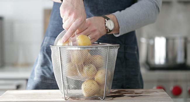 adding potatoes to a basket
