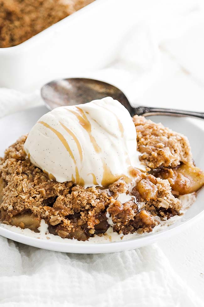 apple crisp on a plate with ice cream and caramel