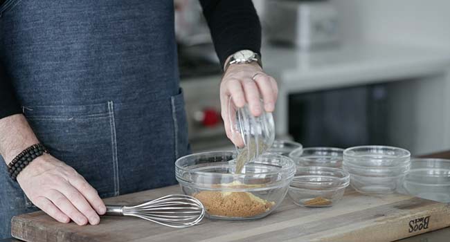 adding spices to a bowl