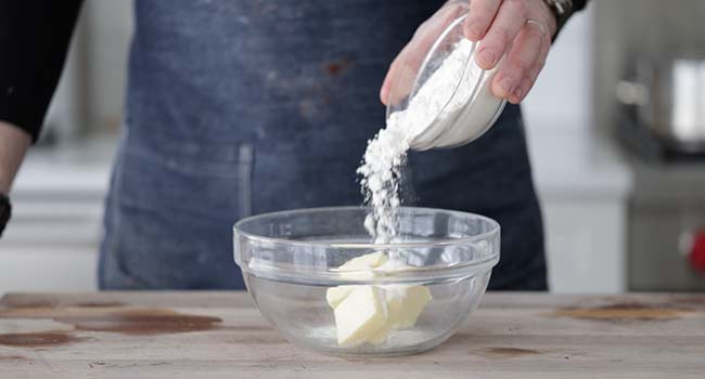 adding flour to butter in a bowl