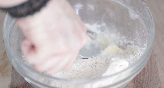 cutting butter into flour in a bowl