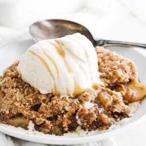 apple crisp on a plate with ice cream and caramel