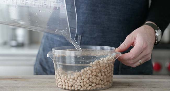 adding water to a container with chickpeas