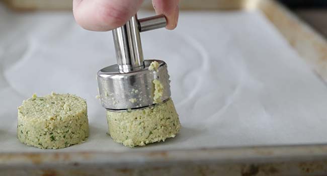 adding falafel to a sheet tray