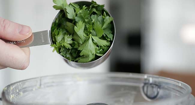 adding parsley to a food processor