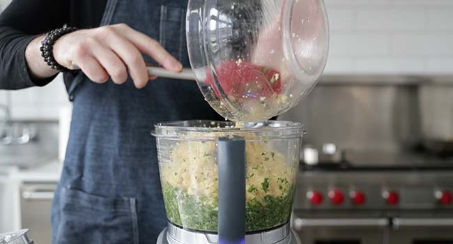 adding processed beans to a food processor