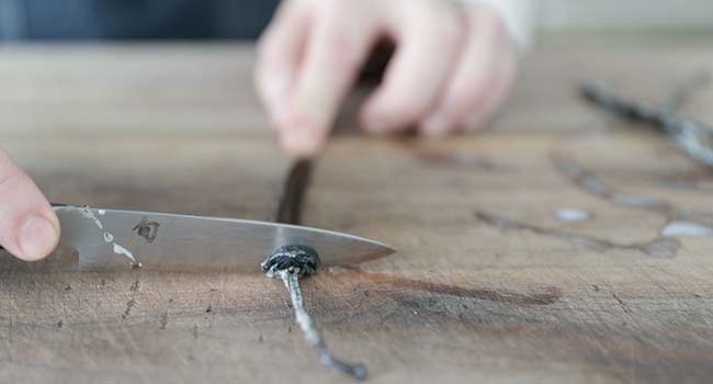 scraping vanilla beans from a vanilla pod