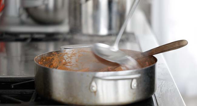 adding hot pasta water to a pan