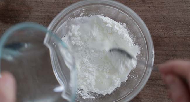 adding water to a bowl of cornstarch