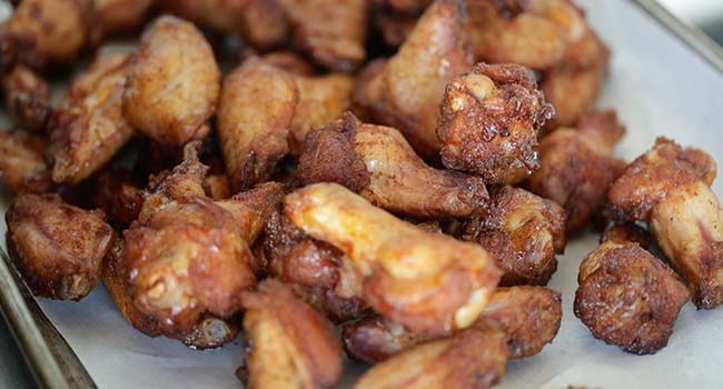 adding smoked wings to a sheet tray