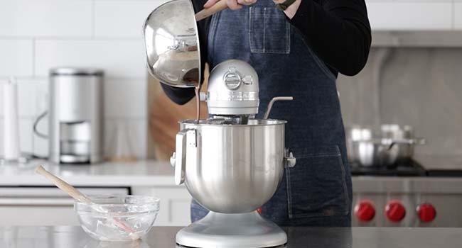 pouring in melted chocolate to a stand mixer