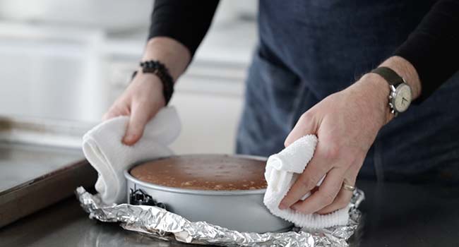 removing a cheesecake from a waterbath