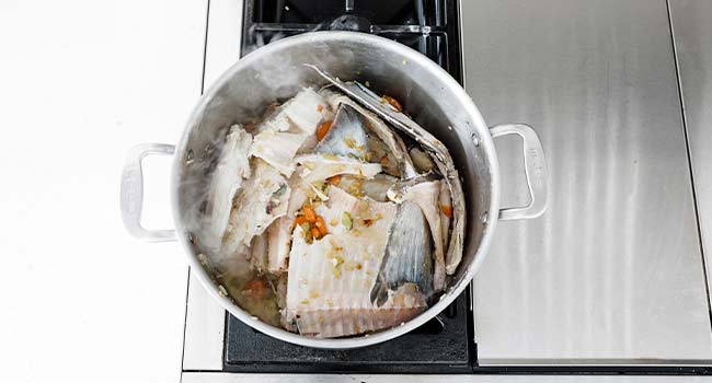 cooking fish bones and vegetables