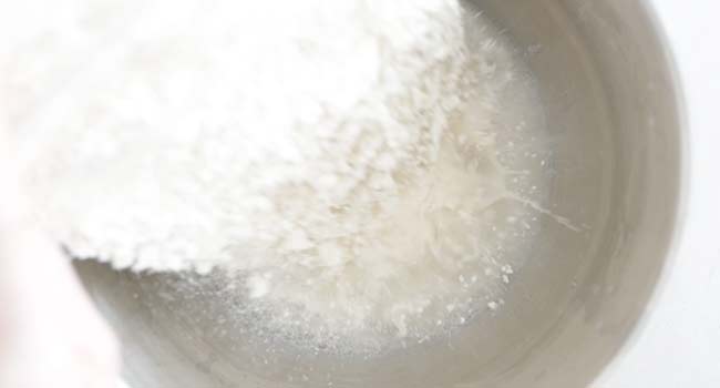 adding flour to yeast