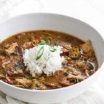 bowl of gumbo with rice and green onions