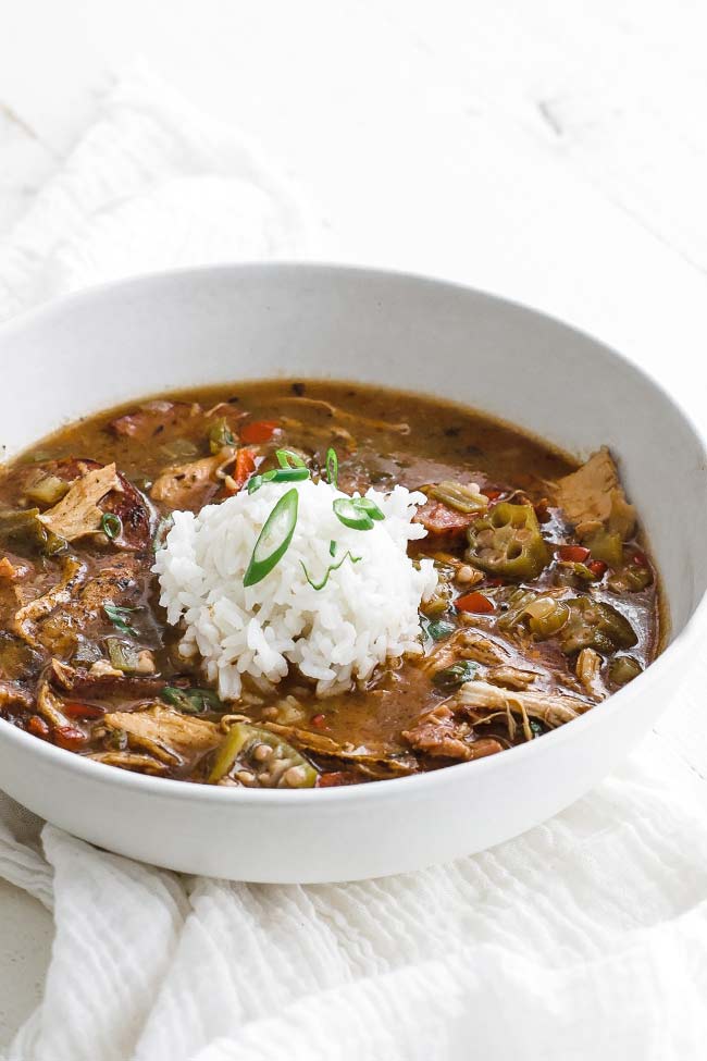 bowl of gumbo with rice and green onions