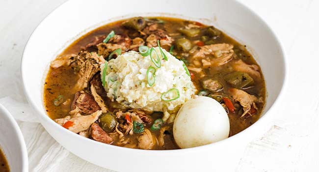 gumbo with potato salad and a hard boiled egg