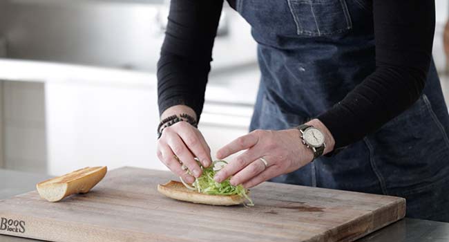 adding lettuce to toasted bread