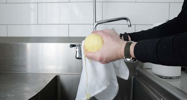 squeezing out liquid from shredded potatoes in a cloth