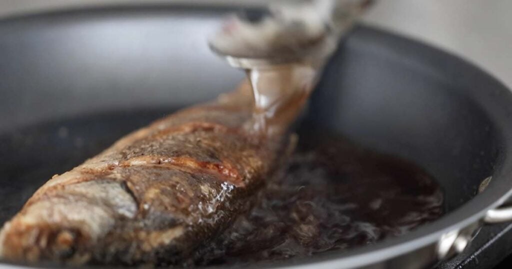 crispy brown branzino in a pan