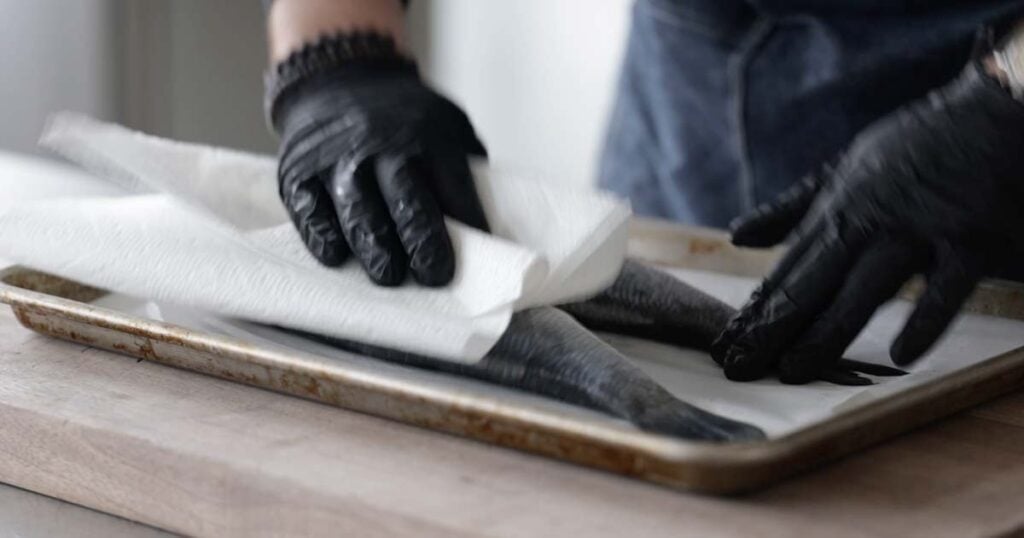 patting dry fish with paper towels