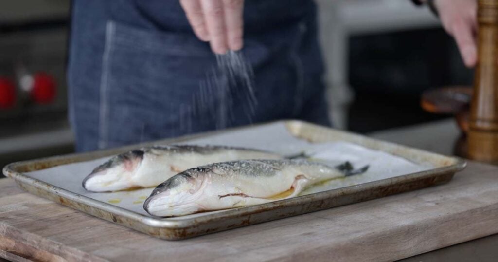 seasoning fish with salt and pepper