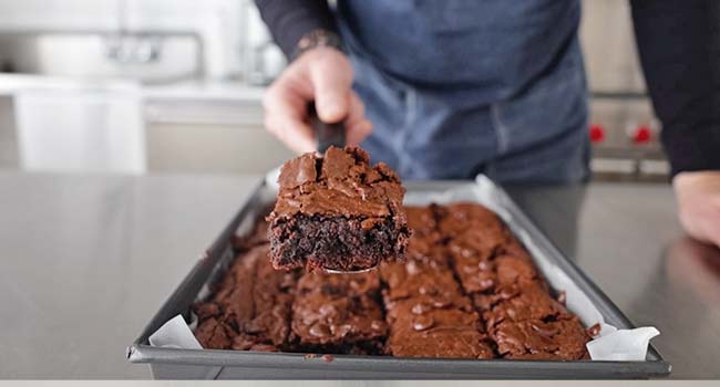 taking out brownie from a pan of brownies