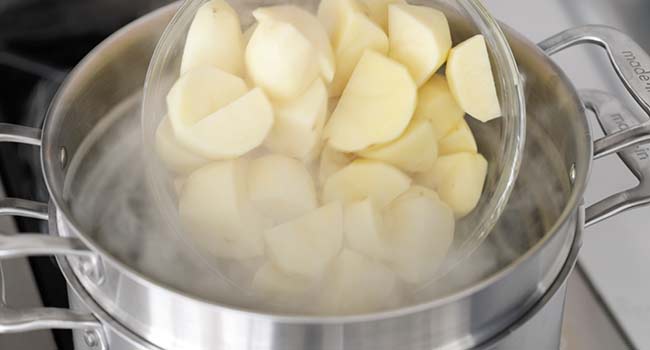 adding potatoes to boiling water