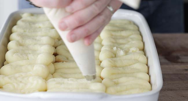 piping potatoes onto cottage pie filling