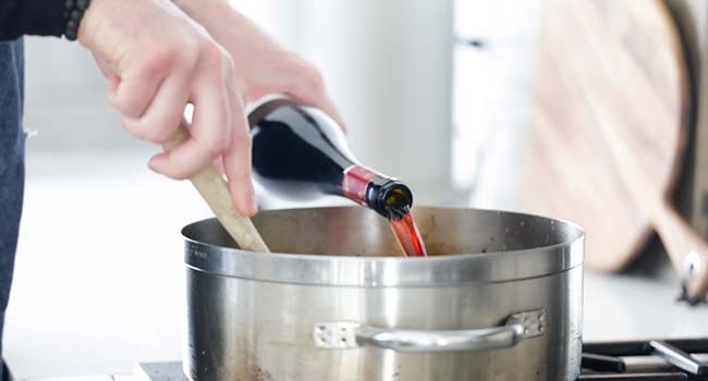adding wine to a pan