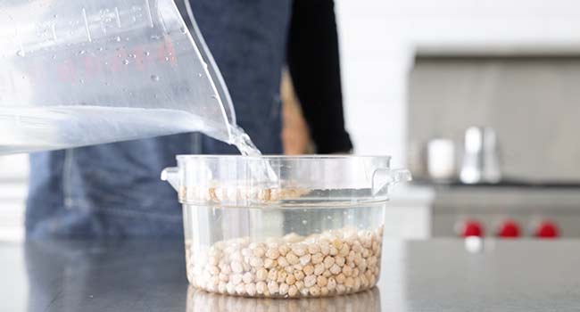 adding water to a container with chickpeas