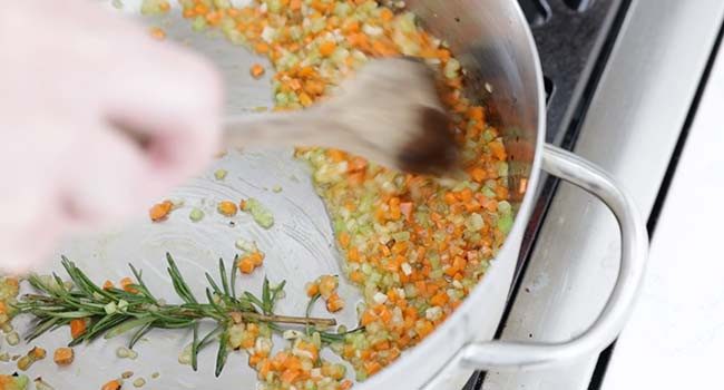 cooking mirepoix and rosemary in a pan