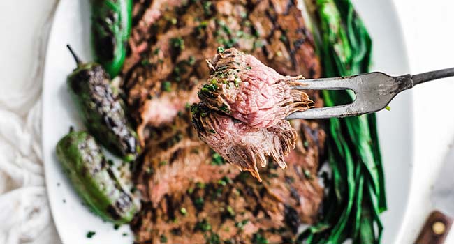 a slice of carne asada on a fork