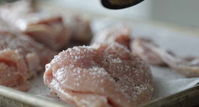 seasoning chicken with salt and pepper