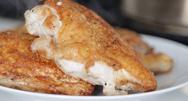 setting cooked chicken to the side on  plate