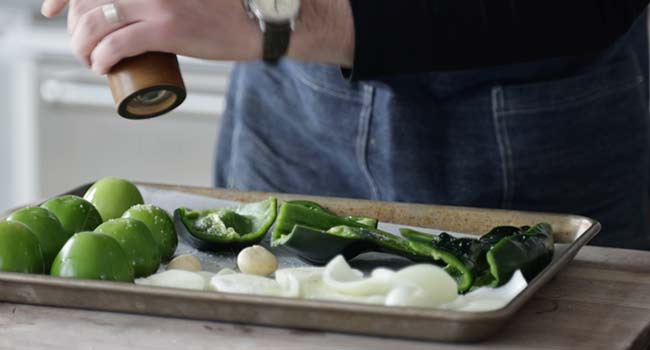 seasoning vegetables on a sheet tray