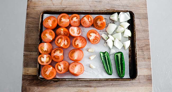 adding vegetables to a sheet tray