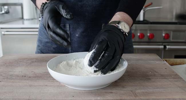 dredging a scotch egg in flour