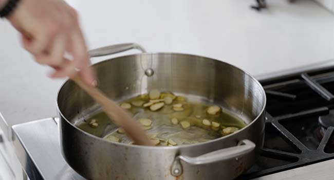 cooking sliced garlic in oil