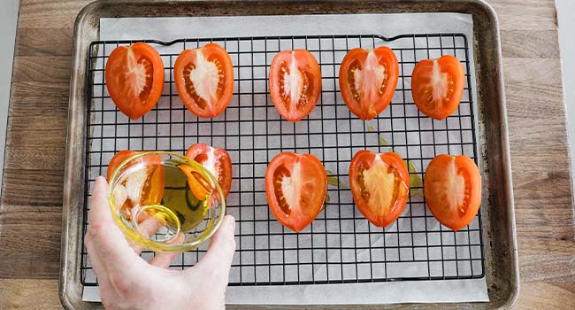 adding olive oil to tomatoes