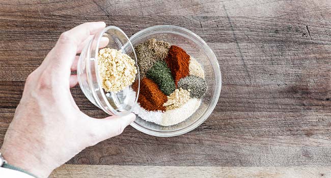 adding seasonings to a bowl