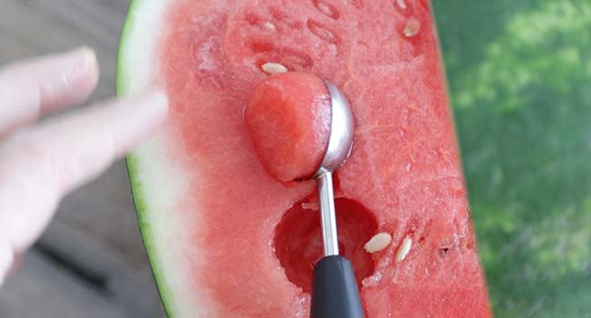scooping out watermelon with a melon baller
