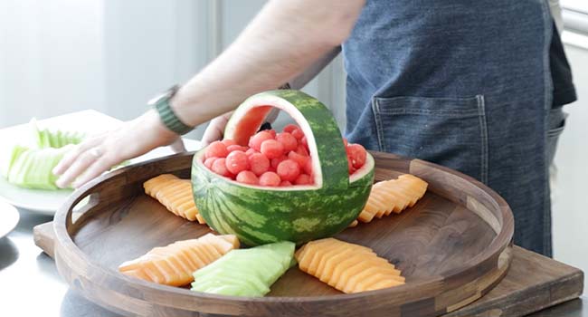placing honeydew melon on a tray