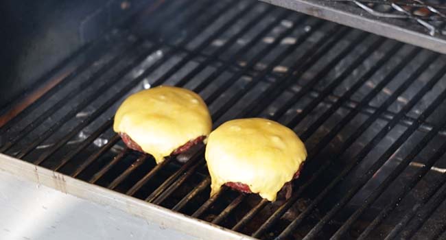 adding cheddar cheese to smoked burgers