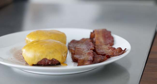 bacon and a cheeseburger on a plate