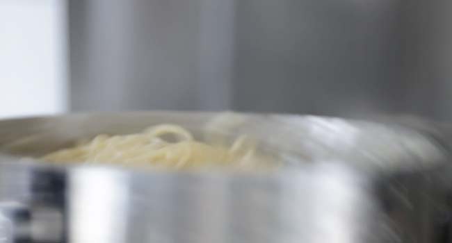 tossing together pasta al limone in a pot