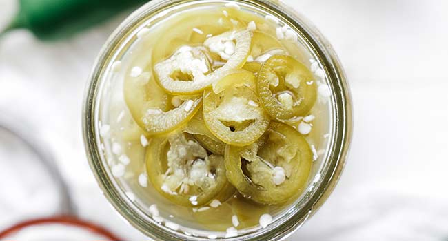 sliced pickled jalapeños in a jar
