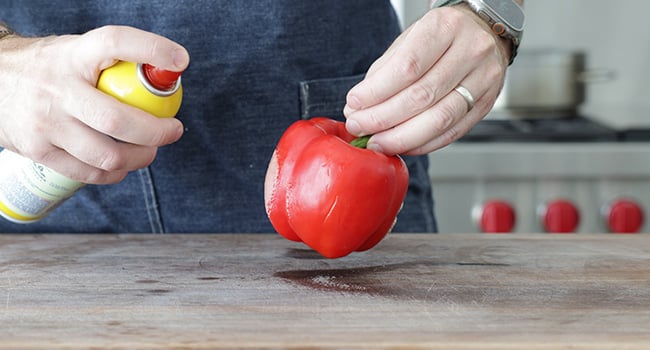 spraying a pepper with non-stick spray