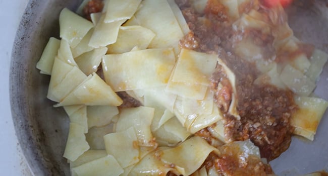 tossing pasta with bolognese