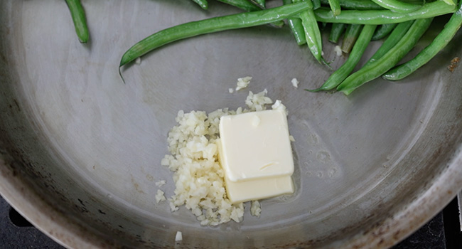 adding butter and garlic to a pan